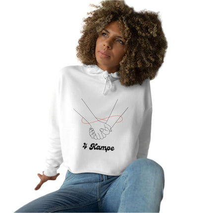 A woman sitting with a casual crop hoodie featuring a minimalist design of two hands and the text '4 KAMPE' on the front.